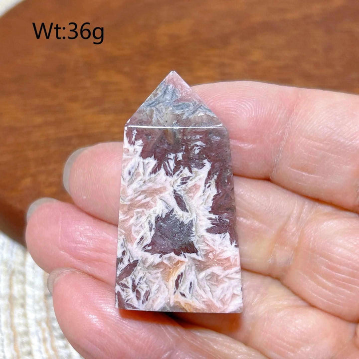 Polished 36g Rhodochrosite tower point featuring raspberry pink and white banding for heart chakra healing and self-love.