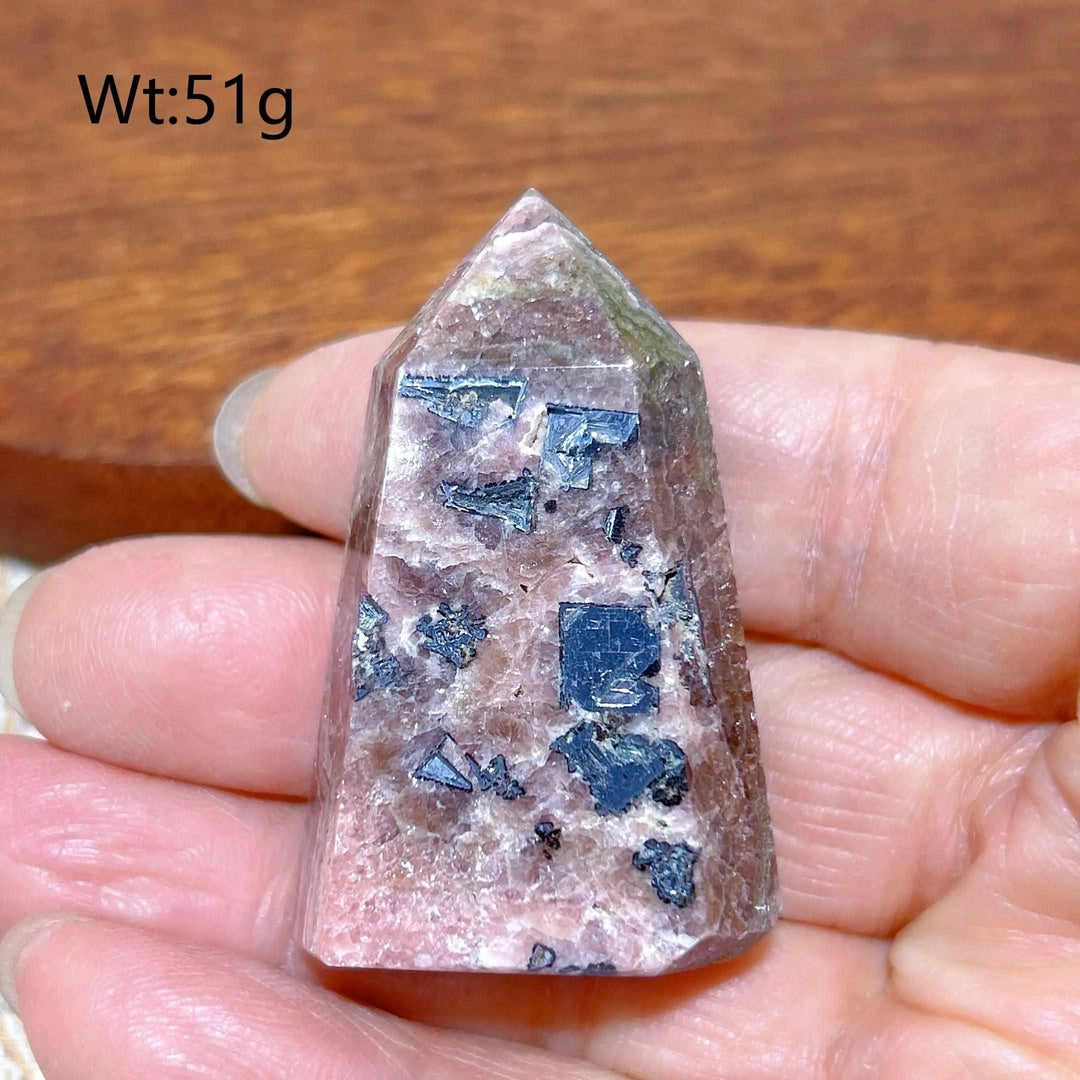 Polished 51g Rhodochrosite tower point featuring raspberry pink tones and unique dark mineral inclusions for heart healing.
