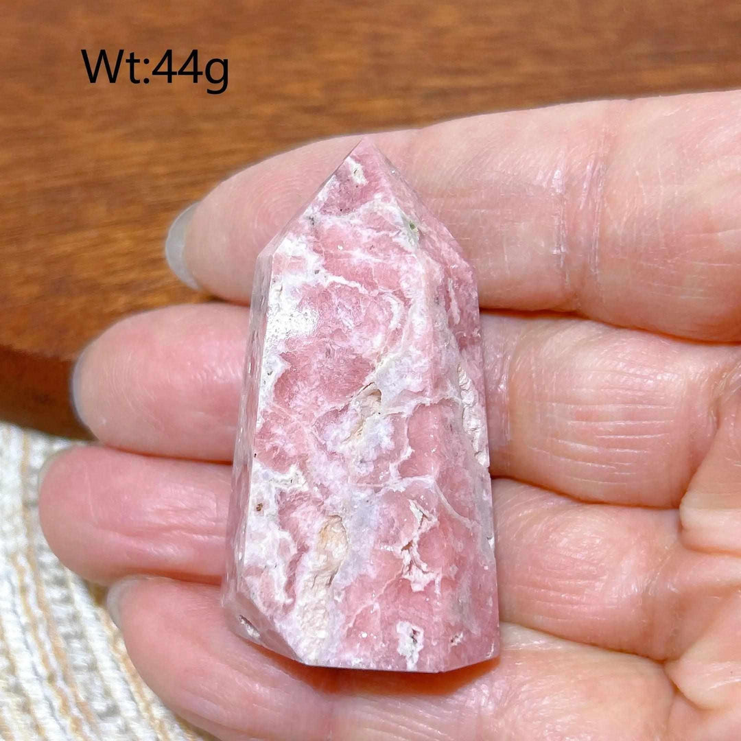 Polished 44g Rhodochrosite tower point featuring beautiful rose pink hues and soft white banding for heart chakra healing.