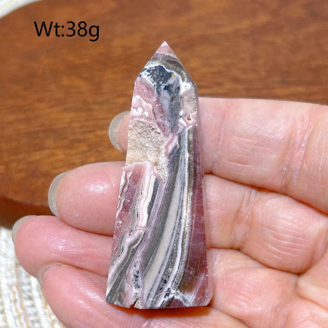 Polished 38g Rhodochrosite tower point featuring beautiful rose pink and white banding for heart chakra healing.