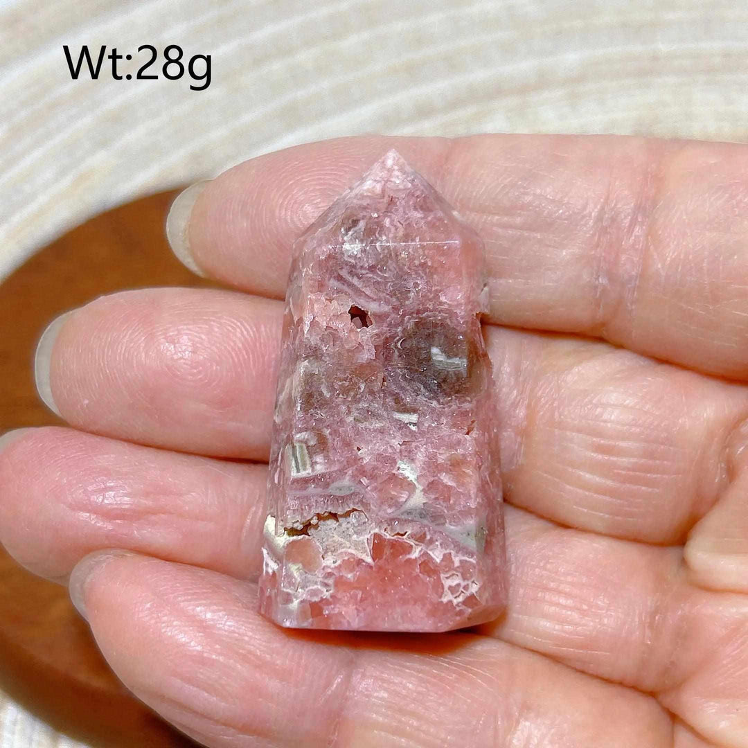 Polished 28g Rhodochrosite tower point featuring raspberry pink hues and white banding for Heart Chakra healing.