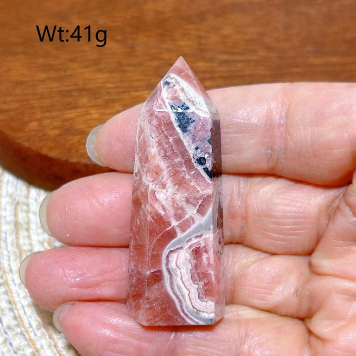Polished 41g Rhodochrosite tower point featuring raspberry pink hues and unique white banding for heart chakra healing.