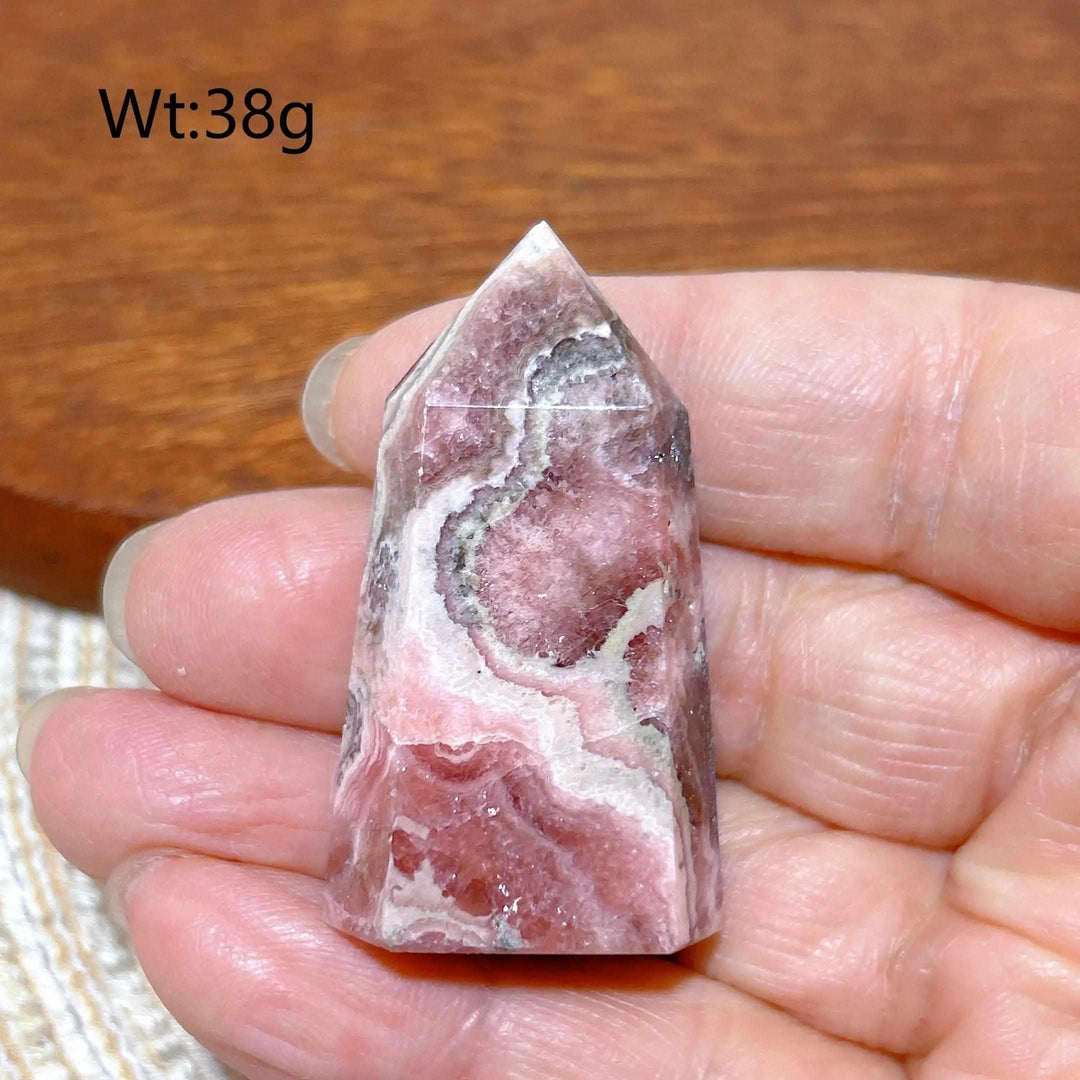Polished 38g Rhodochrosite tower point featuring beautiful rose pink and white banding for heart chakra healing.