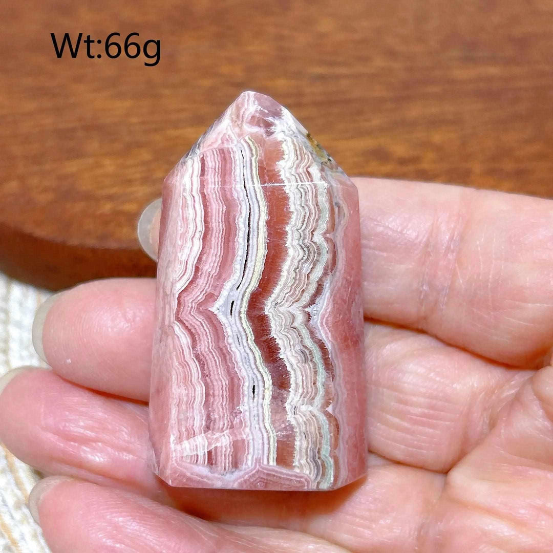 Polished Rhodochrosite tower point featuring beautiful rose pink and white banding for heart chakra healing.