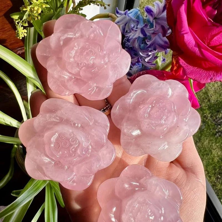 Four gentle pink Rose Quartz crystal carved peony flower sculptures, radiating love and healing energy.