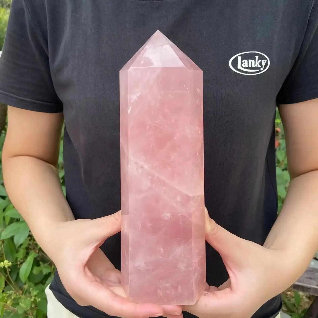 Large, polished rose quartz obelisk tower with a pointed tip, glowing in soft pink for Heart Chakra healing and love.