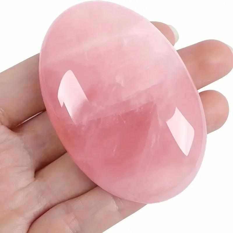 Smooth, polished rose quartz palm stone in a soft pink oval shape, perfect for heart chakra meditation and self-love.