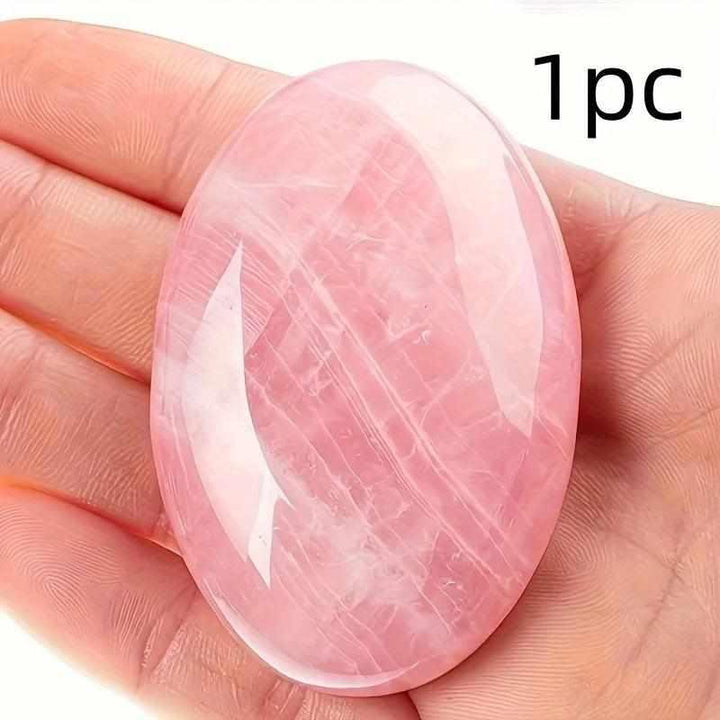 Smooth, oval Rose Quartz palm stone in soft pink, held in hand to promote heart chakra love and gentle self-kindness.