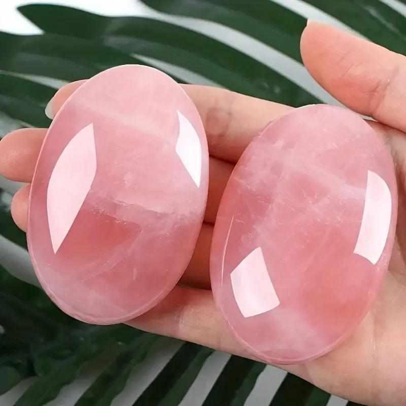 Two smooth, polished rose quartz palm stones in soft pink, perfect for heart chakra meditation and self-love rituals.