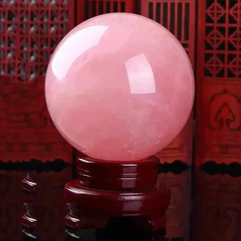 Large rose quartz crystal ball in deep pink, a polished bohemian sphere perfect for romantic decor and healing energy.