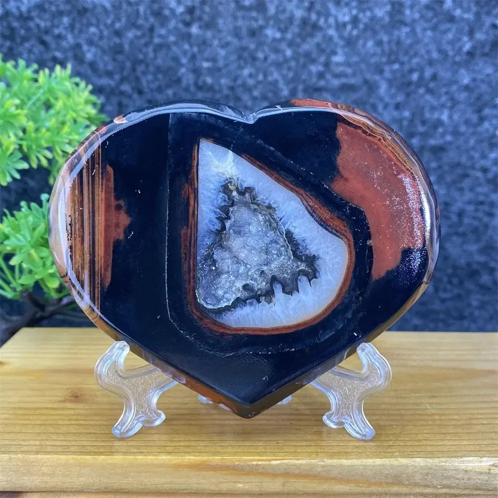 Heart-shaped black and red agate geode with sparkling crystal cave, ideal for feng shui decor.