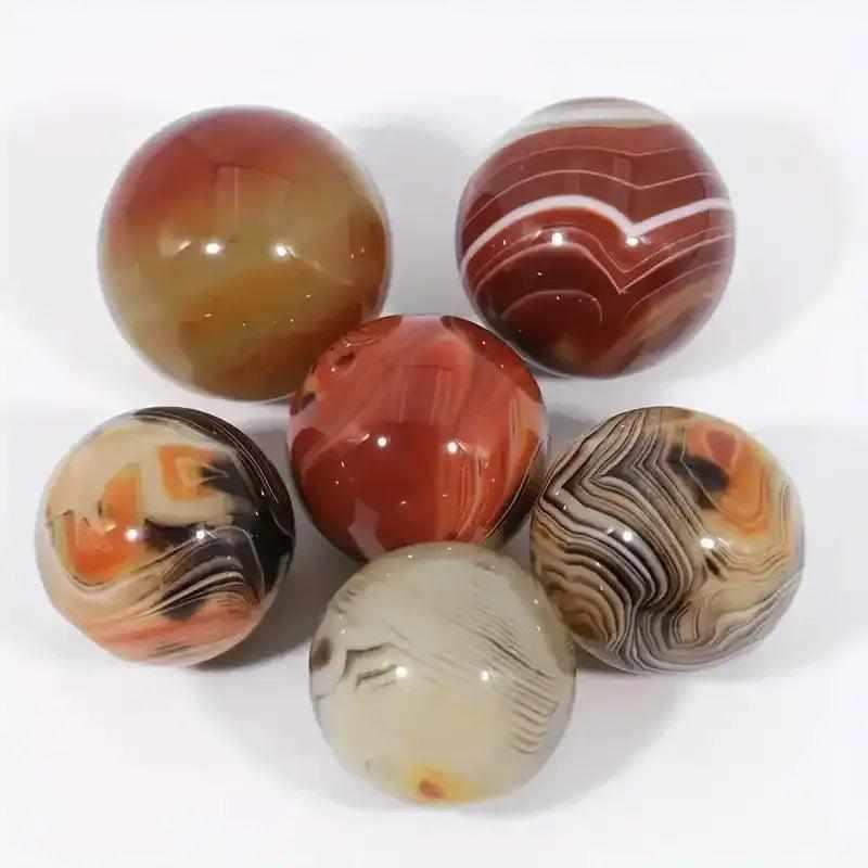 Polished Sardonyx mini spheres featuring unique brown, red, and white bands for strength, stability, and crystal grids.