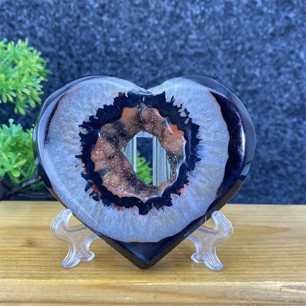 Heart-shaped black and red agate geode with sparkling crystal cave, ideal for feng shui decor.