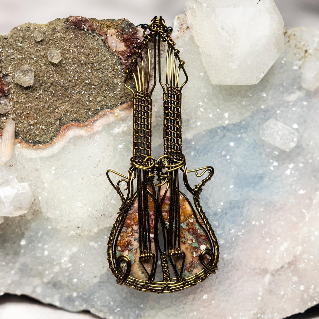 Mesmerizing Sea Sediment Jasper Guitar Wire Wrap Pendant, featuring a unique stone in a handcrafted copper guitar frame.