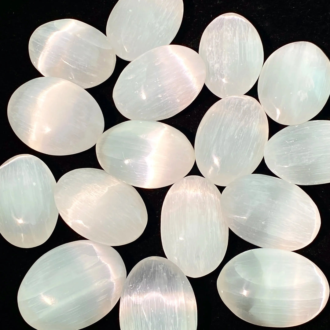 Polished natural white selenite palm stones with a luminous glow, perfect for healing, meditation, and home decor.