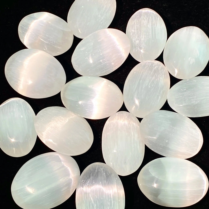 Polished natural white selenite palm stones with a luminous glow, perfect for healing, meditation, and home decor.