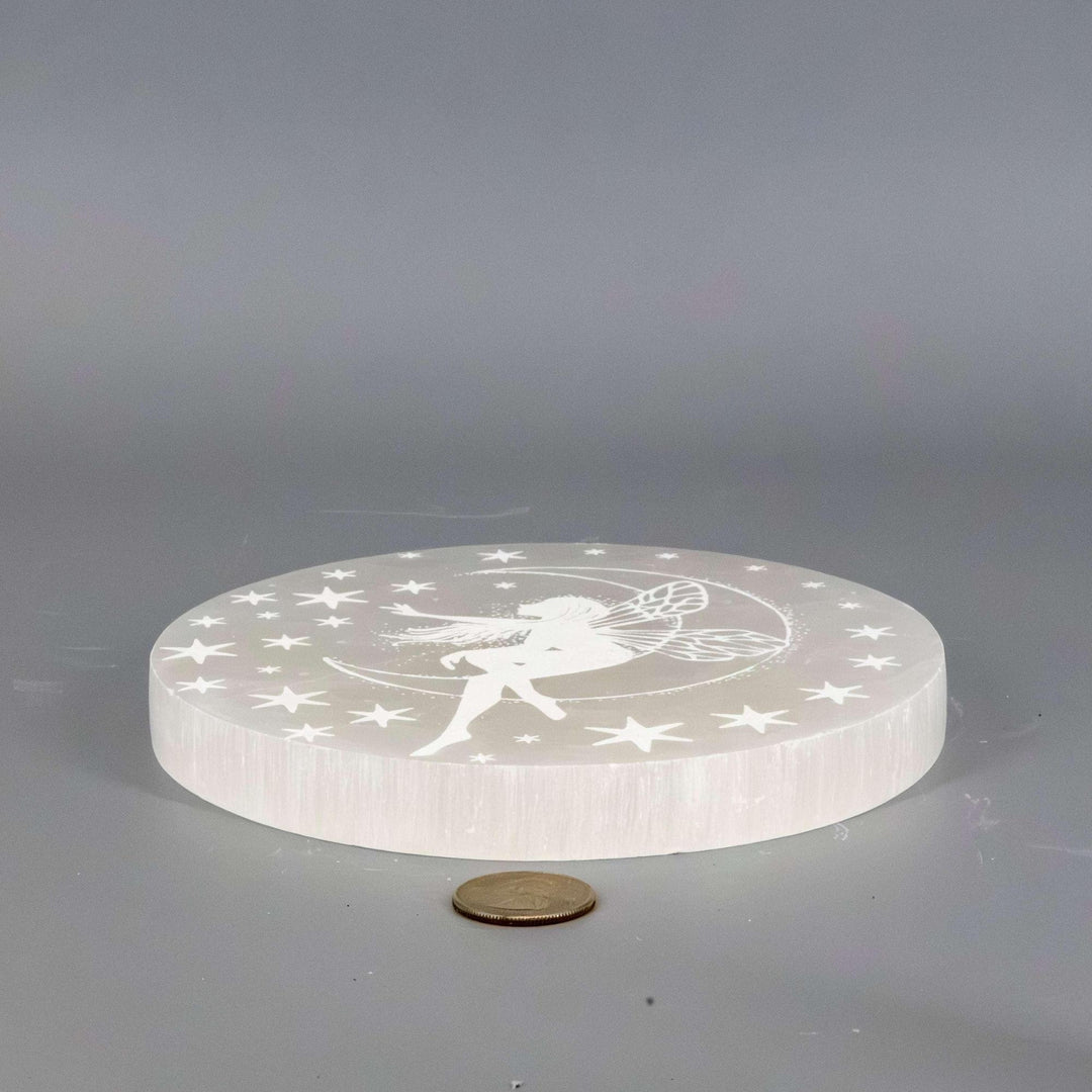 Selenite Crystal Forest Fairy Charging Plate, a translucent white disc with an etched fairy and stars.