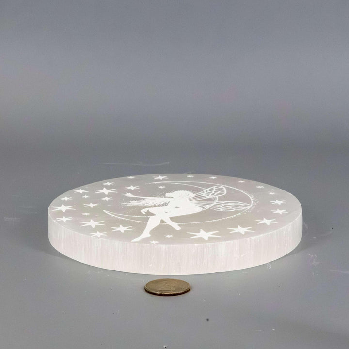 Selenite Crystal Forest Fairy Charging Plate, a translucent white disc with an etched fairy and stars.