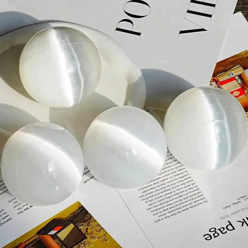 Polished white Selenite crystal spheres with a silky, glowing sheen for peaceful energy and Crown Chakra cleansing.
