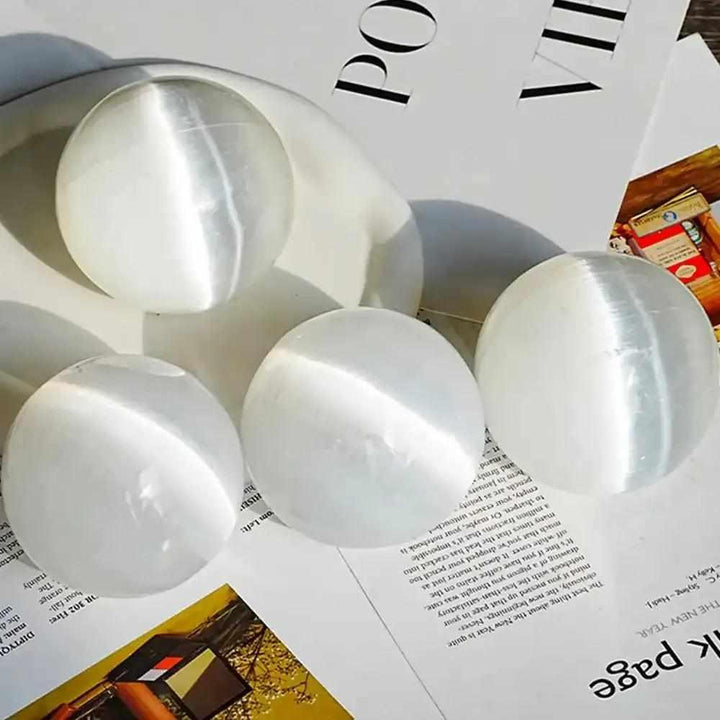 Polished white Selenite crystal spheres with a silky, glowing sheen for peaceful energy and Crown Chakra cleansing.