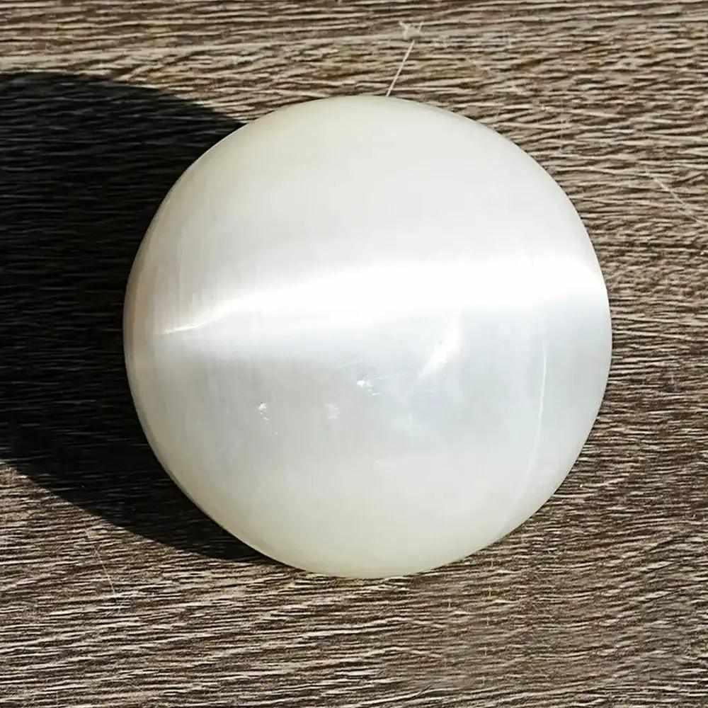 Polished white Selenite crystal sphere with a silky, glowing sheen, perfect for Crown Chakra cleansing and meditation.
