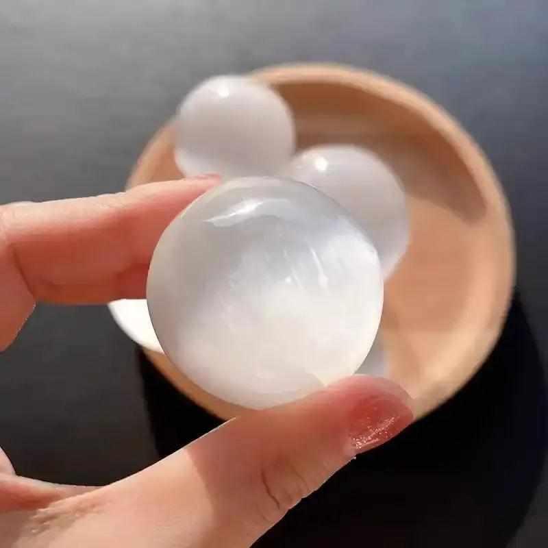 Polished white Selenite crystal sphere with a silky, glowing sheen for peaceful energy and Crown Chakra cleansing.