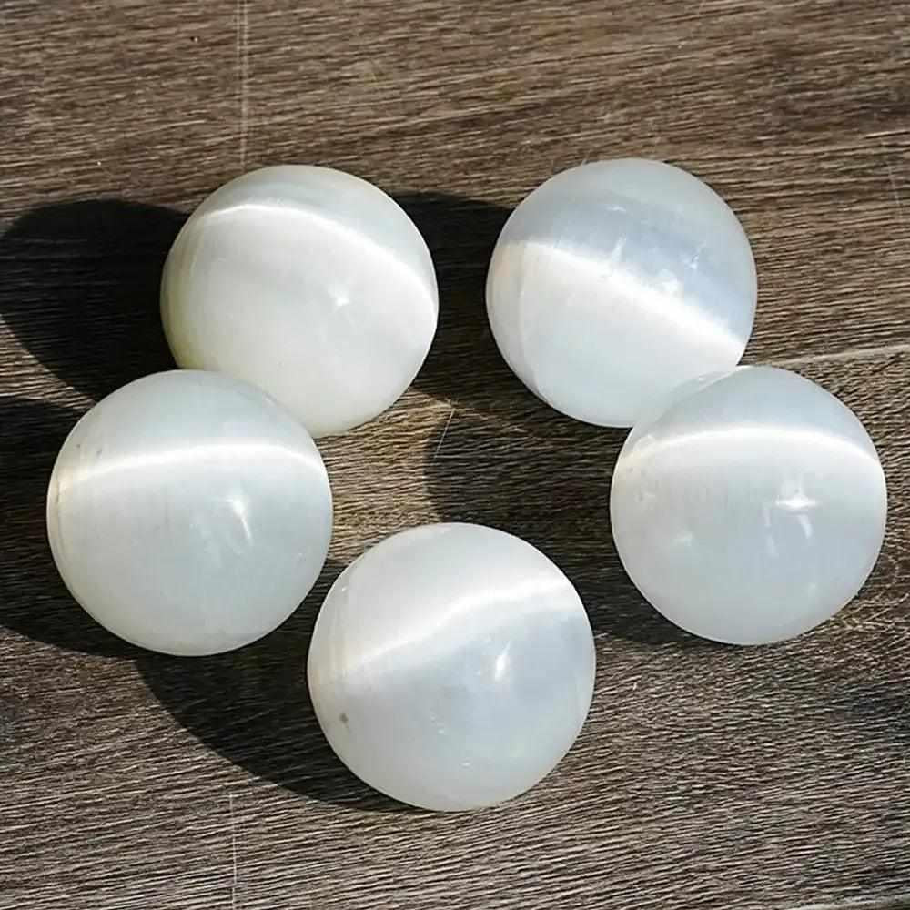 Polished white Selenite crystal spheres with a silky, glowing sheen, perfect for Crown Chakra cleansing and meditation.