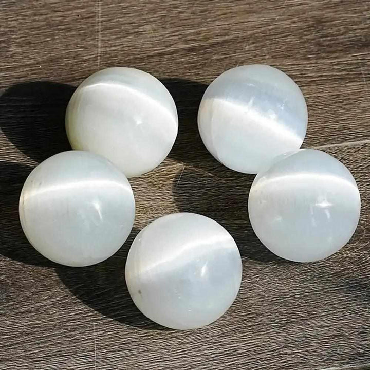 Polished white Selenite crystal spheres with a silky, glowing sheen, perfect for Crown Chakra cleansing and meditation.