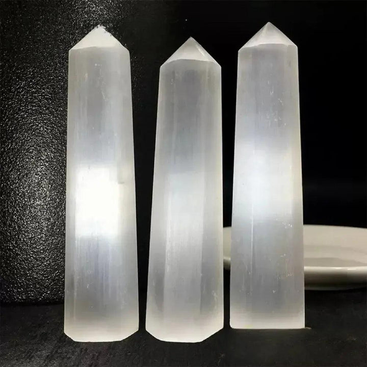 Three luminous white Selenite hexagonal obelisk towers for cleansing energy and Crown Chakra meditation.
