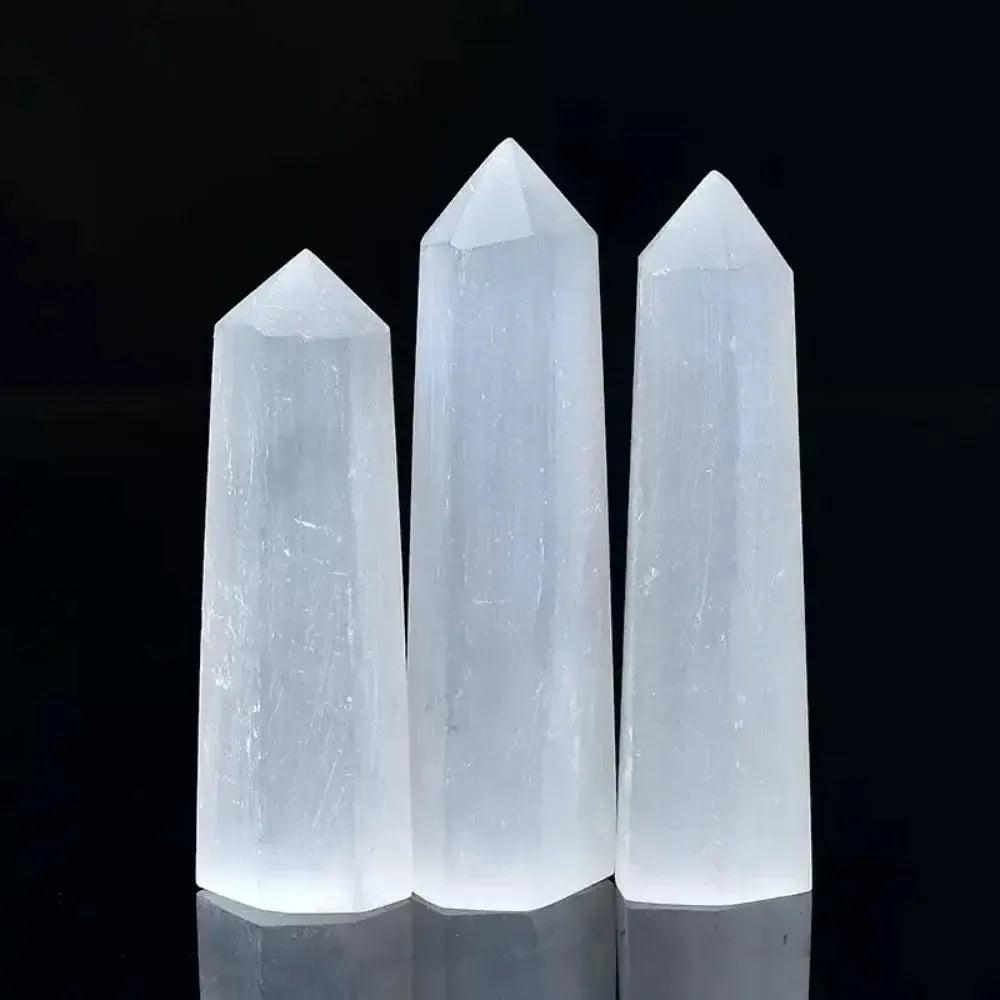 Three luminous white Selenite hexagonal obelisk wands for cleansing energy, meditation, and crown chakra alignment.