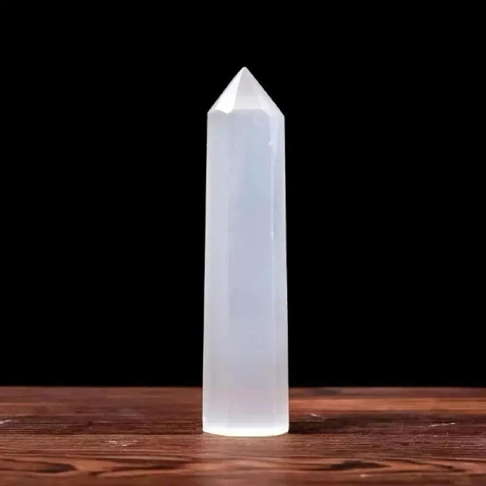 Luminous white Selenite crystal hexagonal obelisk tower for Crown Chakra meditation and spiritual energy cleansing.