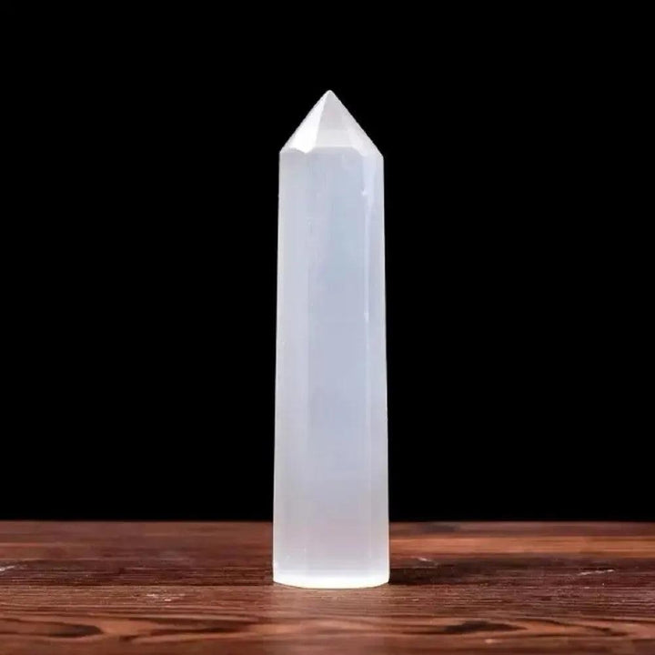 Luminous white Selenite crystal hexagonal obelisk tower for Crown Chakra meditation and spiritual energy cleansing.