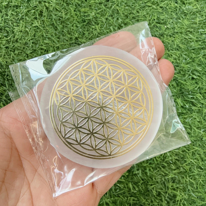 Selenite Flower of Life Crystal Charging Plate Slab, a white fibrous gypsum disk with a gold sacred geometry engraving.