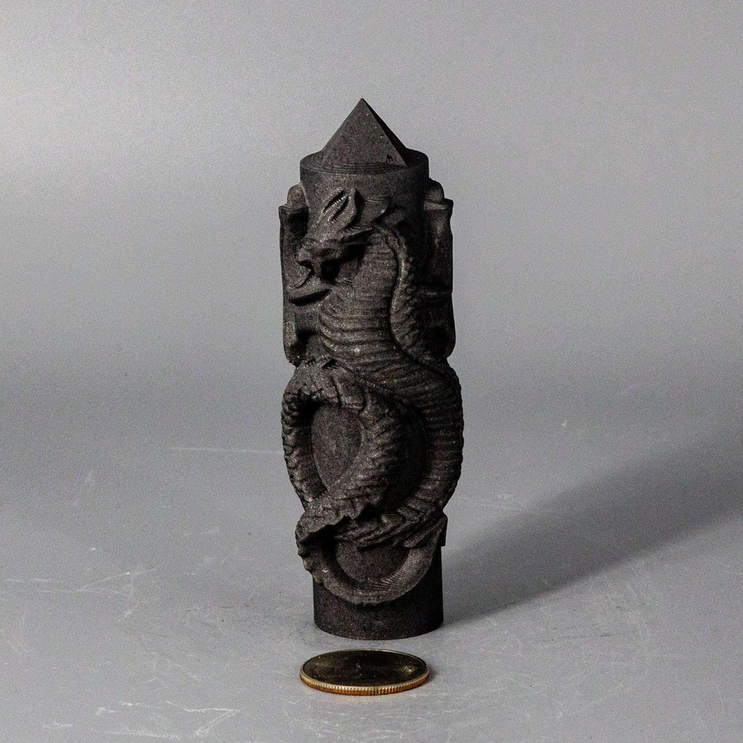 Dark Shungite CNC Carved Dragon Tower, 4" tall, with intricate scales and a powerful presence, beside a coin.