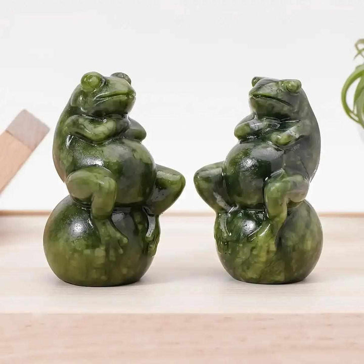 Hand-polished Serpentine jade frog carving on a ball, featuring mottled forest and olive green tones for renewal.