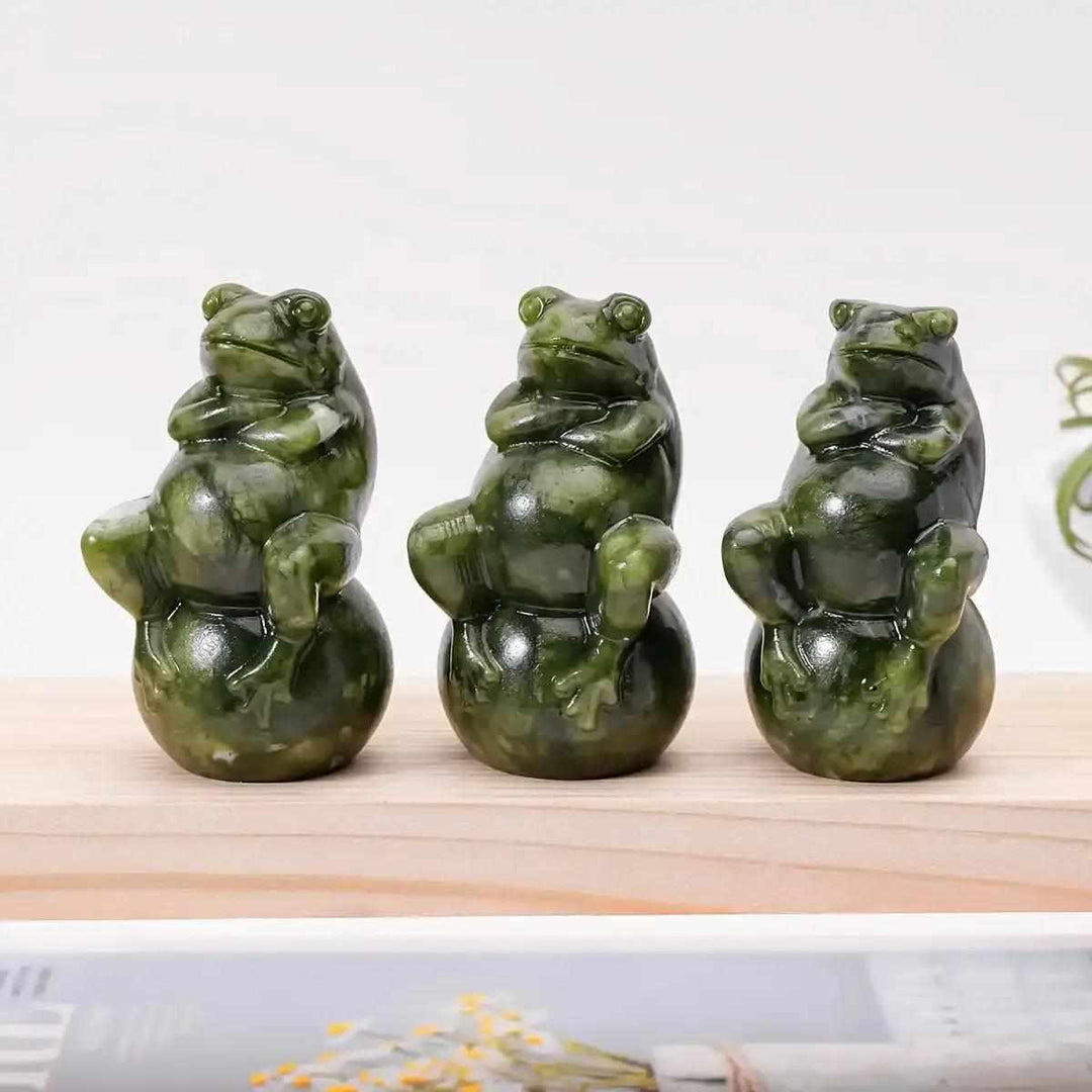 Three polished Serpentine Jade frog carvings seated on round balls, featuring mottled forest and olive green tones.