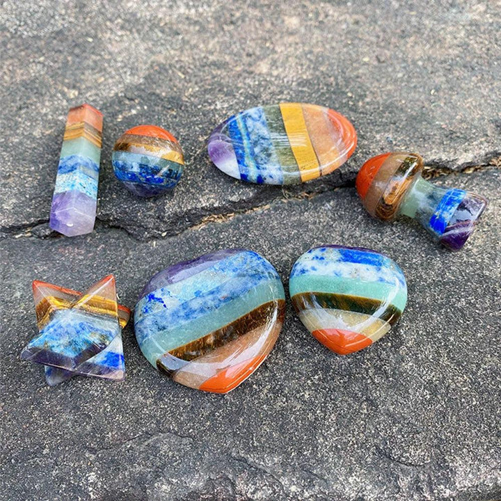 Polished Seven Chakra Crystal Fused stones in various shapes, showcasing vibrant layers of natural healing crystals.