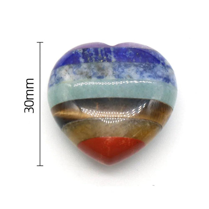 Polished 30mm heart-shaped Seven Chakra Crystal Fused Stone with vibrant layers for energy work and healing.