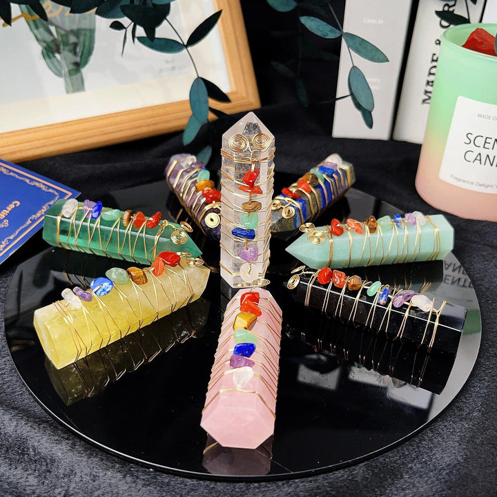Rose Quartz, Amethyst, and other chakra crystal towers with copper wire winding, arranged on a black tray.