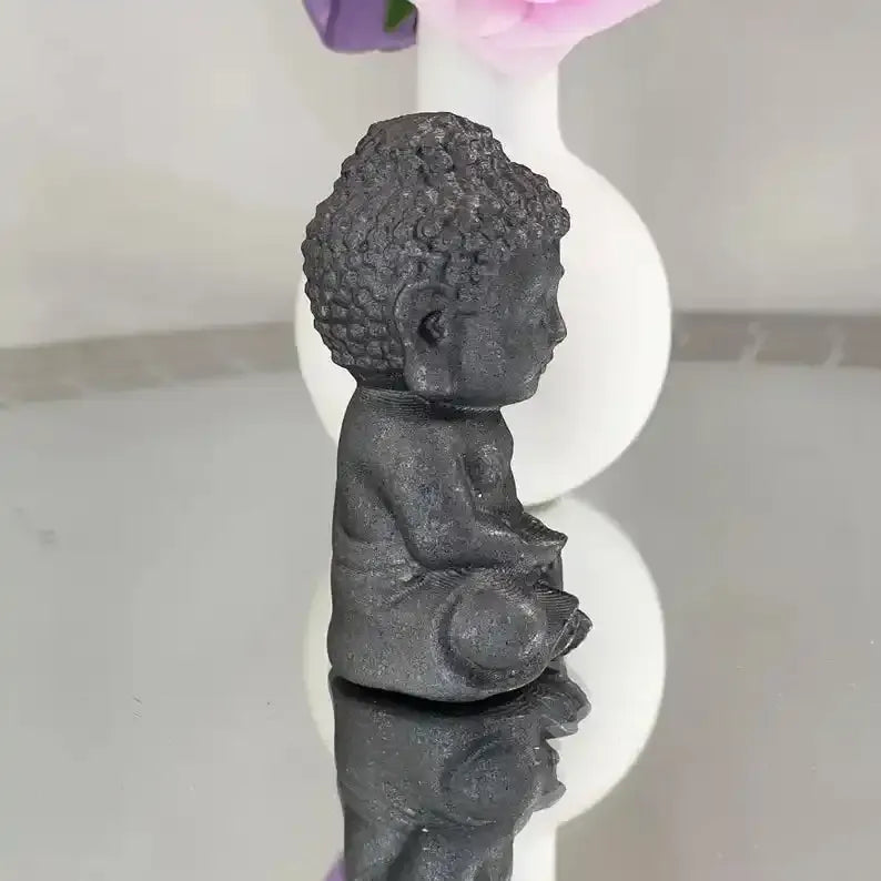 80mm black Shungite Buddha carving, a grounding stone sculpture with detailed robes and curls for meditation spaces.