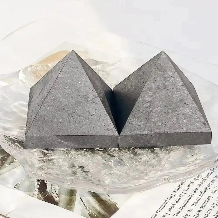 Hand-polished Shungite crystal pyramid with a satin black, carbon-rich surface for grounding and Root chakra protection.