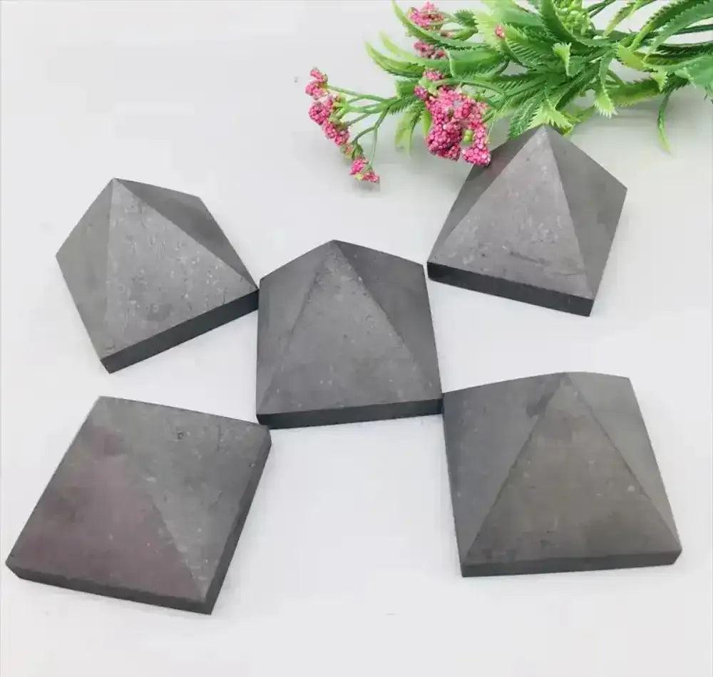Hand-polished satin black Shungite crystal pyramids for Root chakra grounding, protection, and sacred energy work.