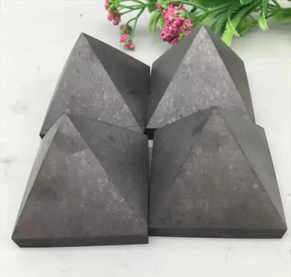 Four hand-polished satin black Shungite crystal pyramids for grounding, protection, and sacred energy work.