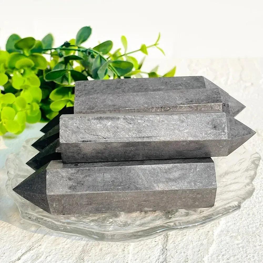 Dark gray Shungite Crystal Towers from Crystal Destiny, showcasing their natural texture and pointed design.