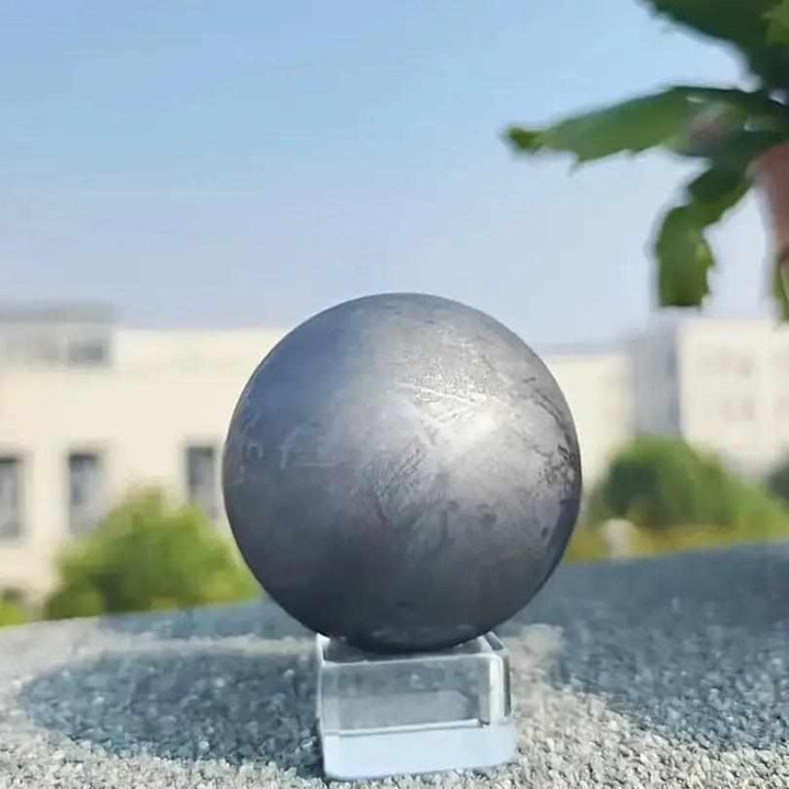 Polished black Shungite sphere with a metallic sheen, perfect for root chakra grounding and protective energy.