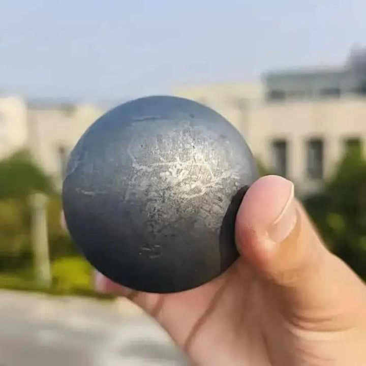 Polished black Shungite sphere with a satiny metallic sheen, perfect for root chakra grounding and protective energy.