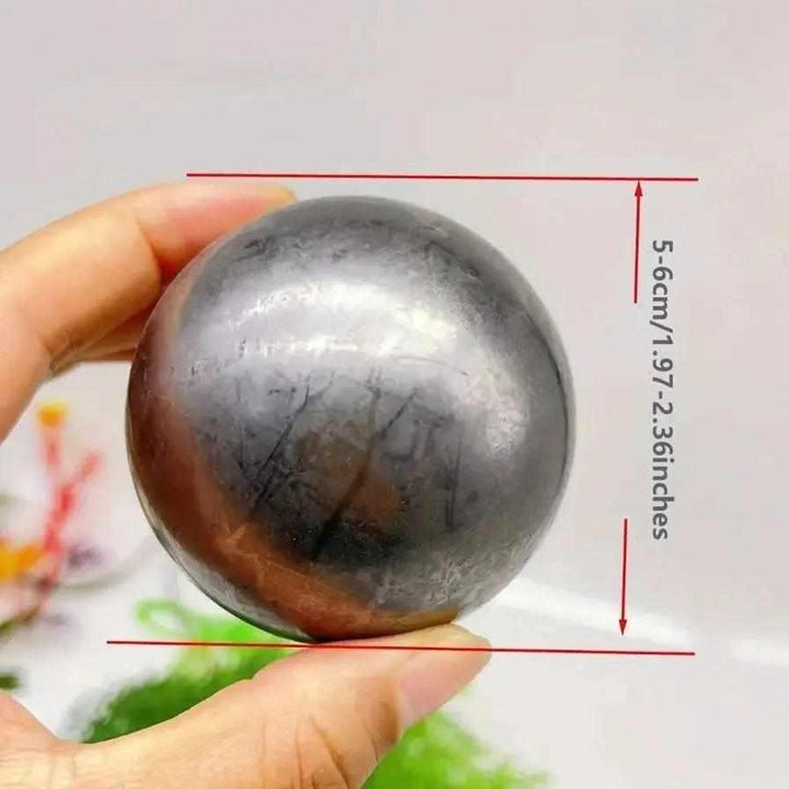 Polished black Shungite sphere for grounding and protection, featuring a smooth metallic sheen in a 5-6cm size.