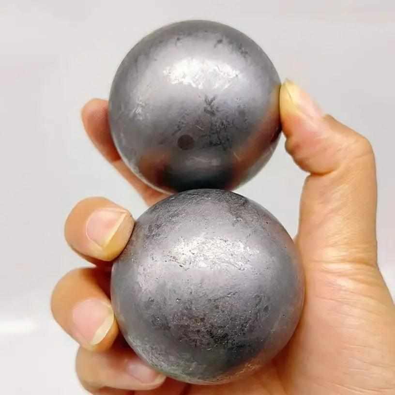 Two polished, deep black Shungite spheres with a metallic sheen, perfect for grounding and root chakra protection.