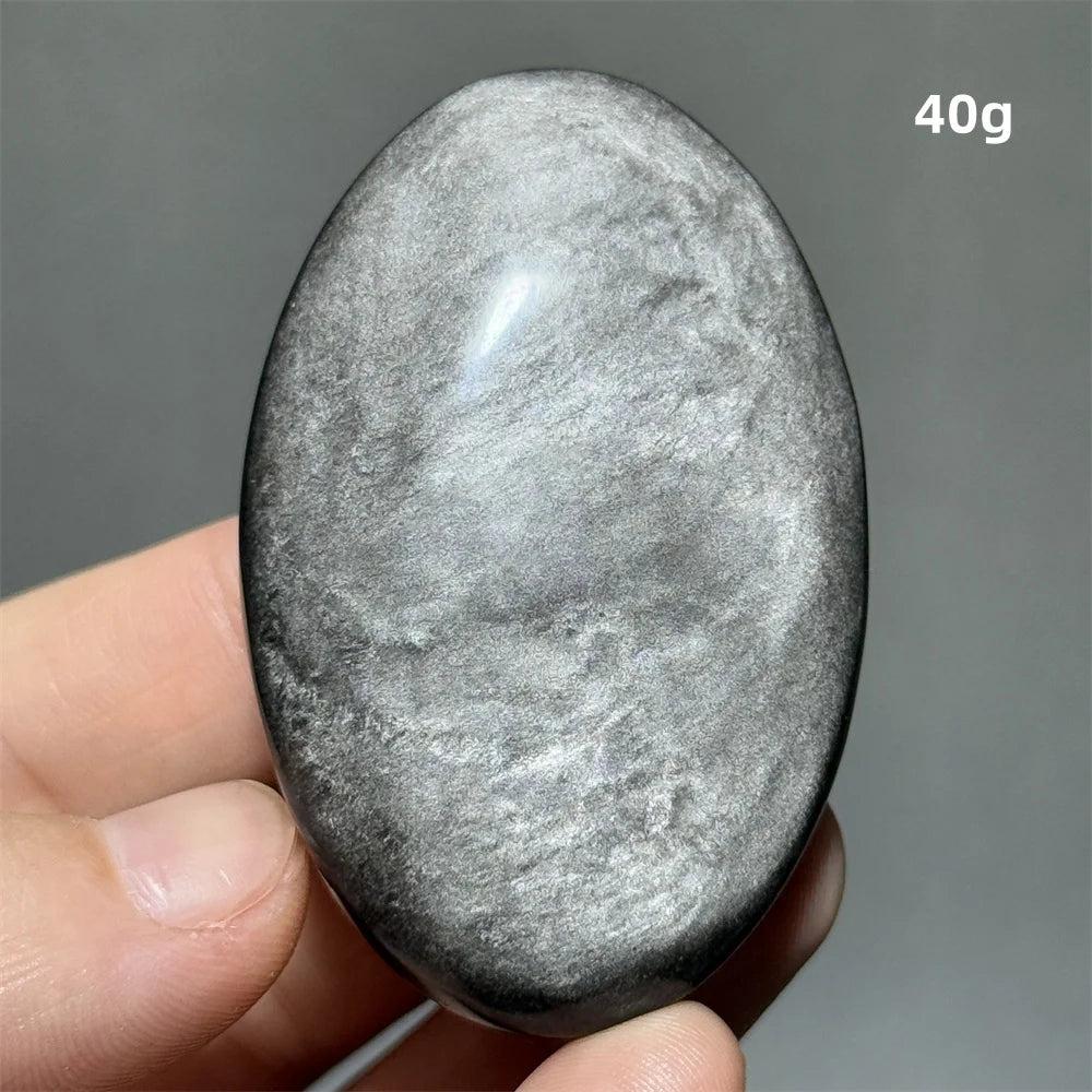 Polished 40g silver sheen obsidian palm stone with a glossy black surface and reflective metallic shimmer for grounding.