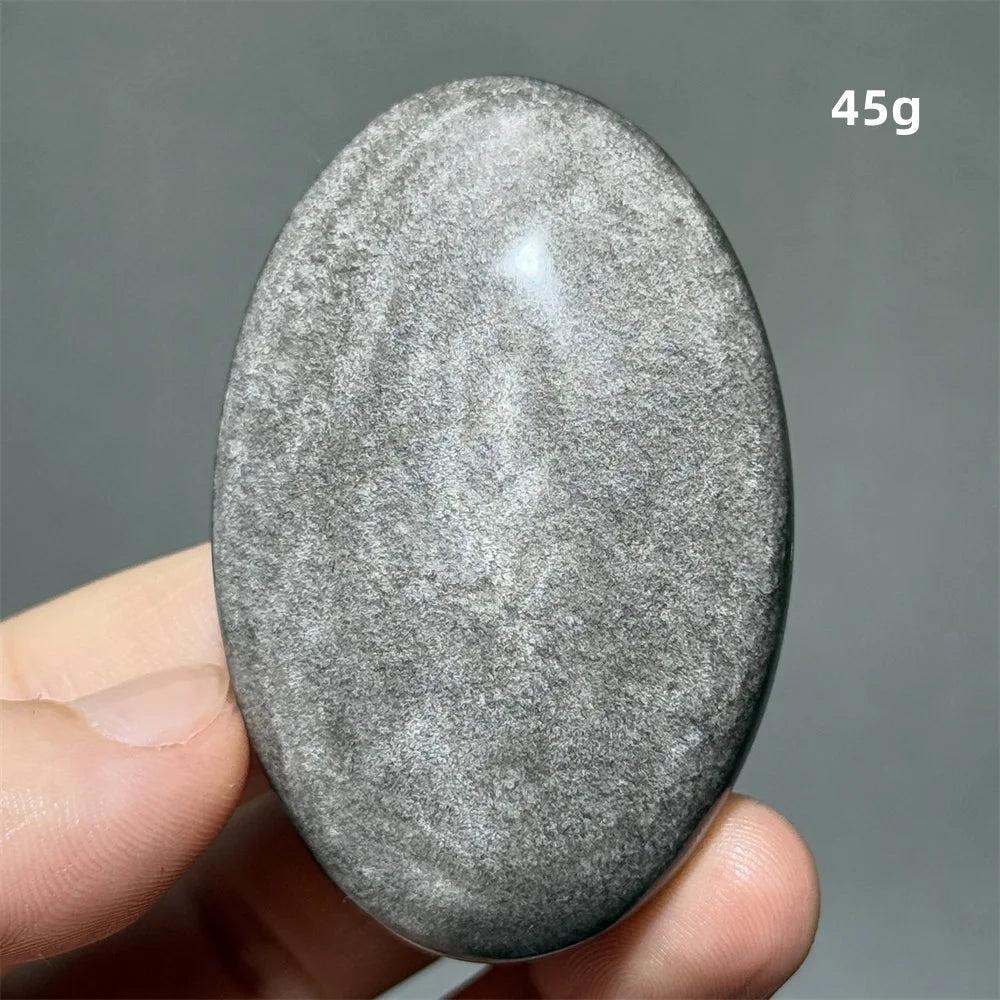 Polished 45g Silver Sheen Obsidian palm stone with a glossy black surface and shimmering silver reflection for grounding.